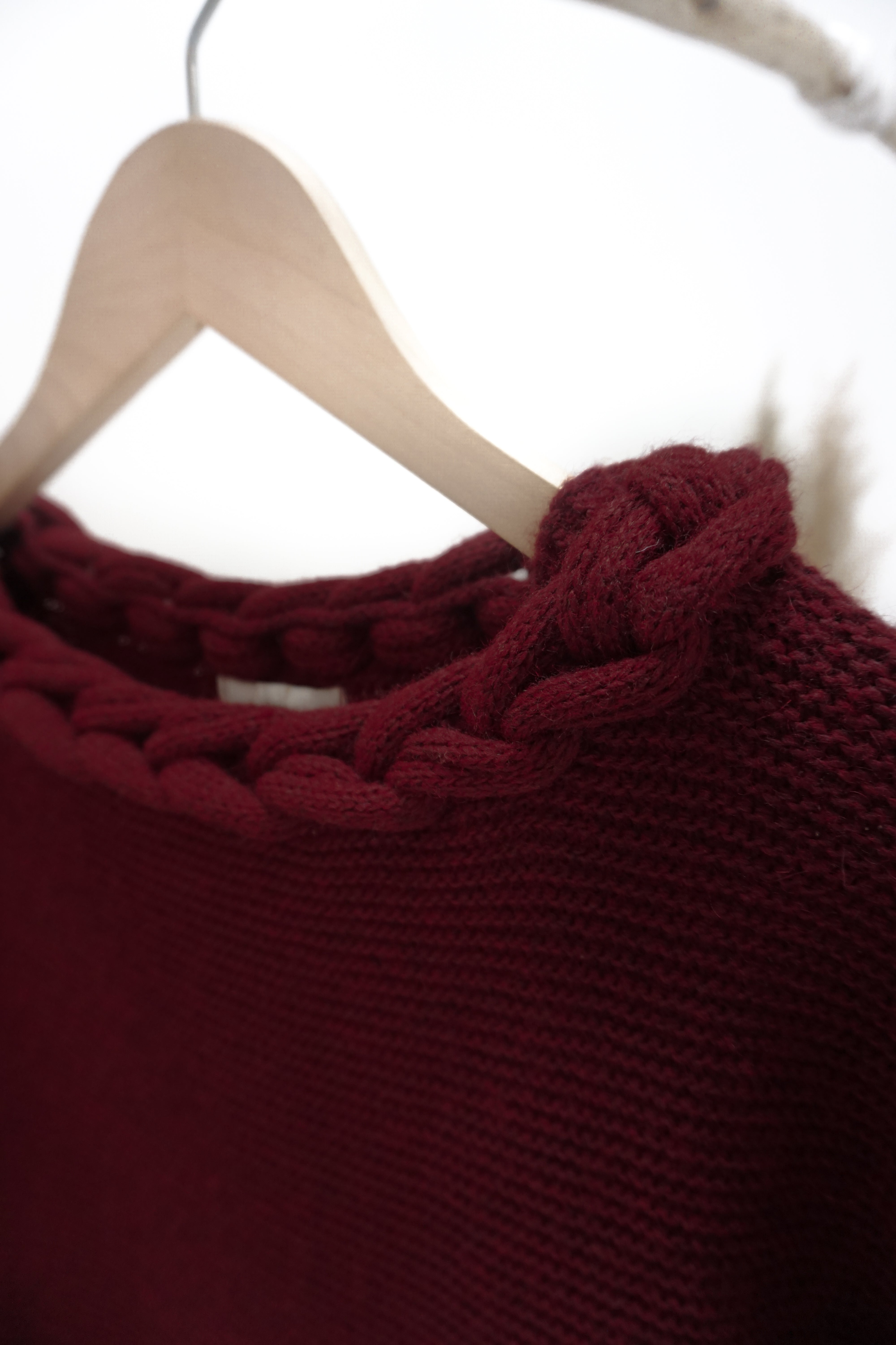 Strickpulli mit geflochtenem Ausschnitt